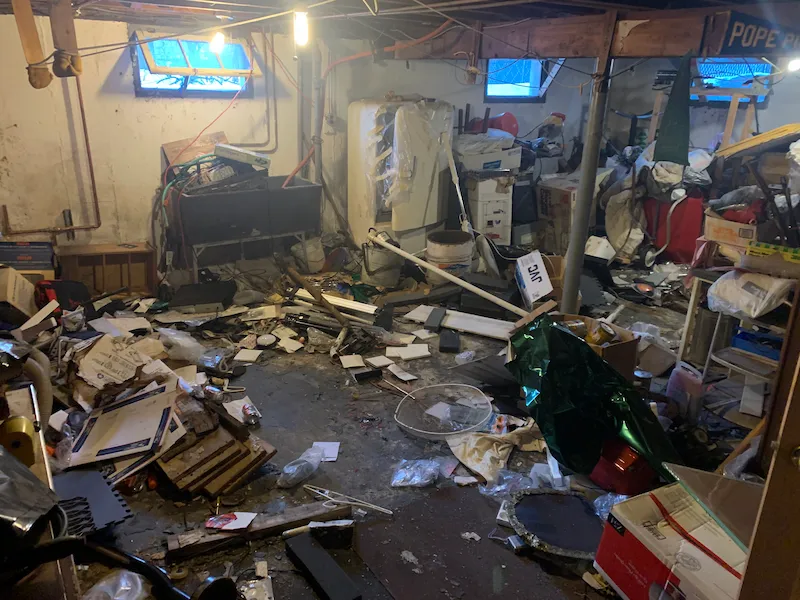 A flood-damaged North Jersey basement filled with wet debris before JunkDoctors performed a full flood cleanout.