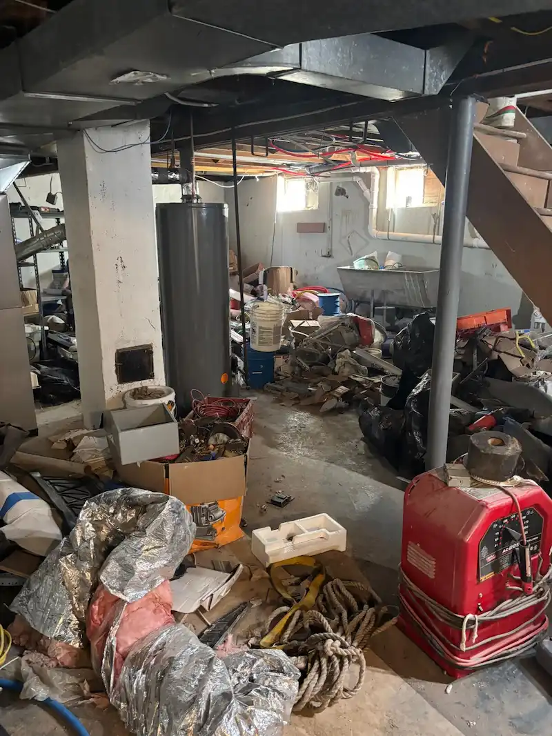 A Fair Lawn, North Jersey basement filled with construction debris, old insulation, and household junk before being cleared by JunkDoctors.