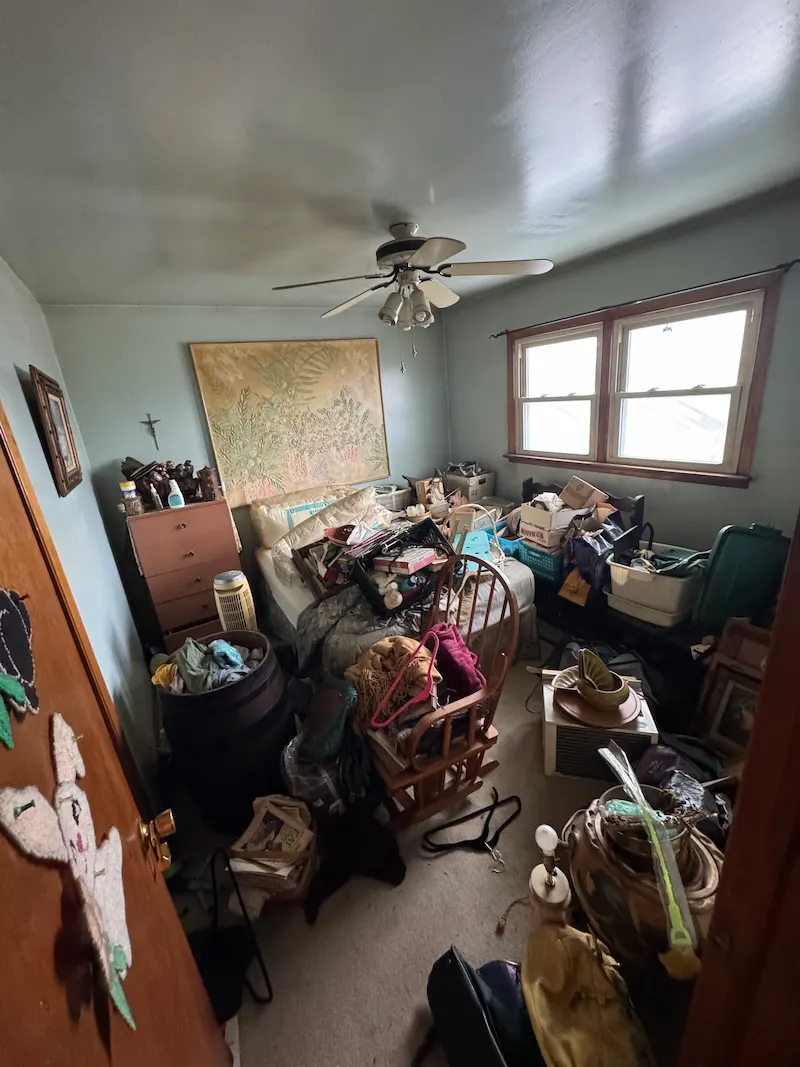 A New Jersey residential bedroom completely overwhelmed with extreme clutter before JunkDoctors' foreclosure cleanout service.