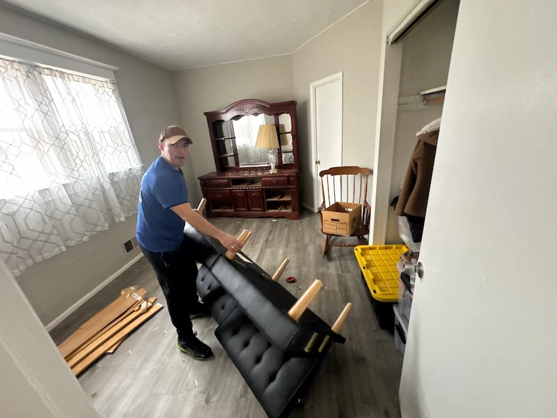 Furniture-filled room before cleanout service in New Jersey