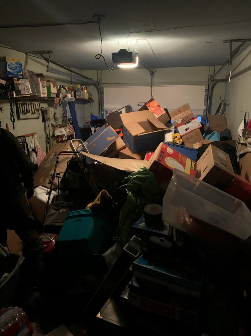 A Morristown, North Jersey garage packed with clutter, boxes, and old items before a JunkDoctors cleanout.