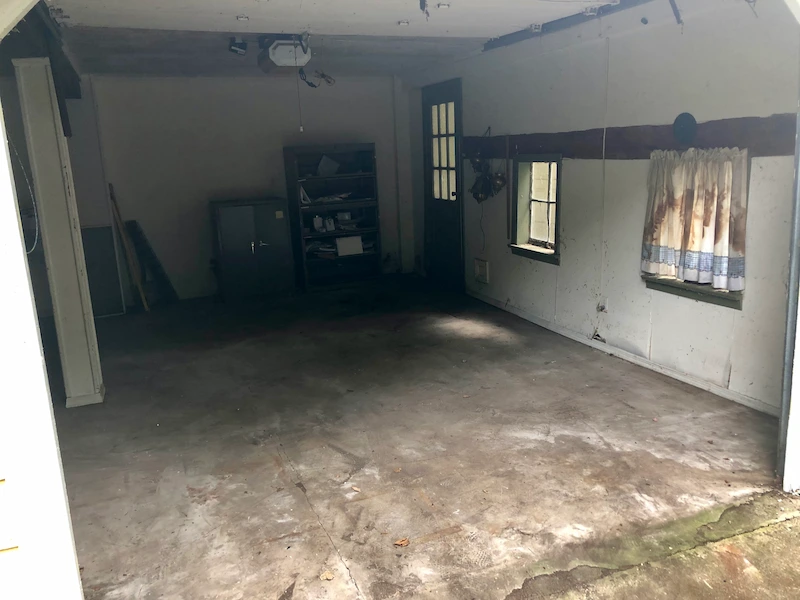 A completely cleared and swept garage floor in a North Jersey home after professional junk removal by JunkDoctors.