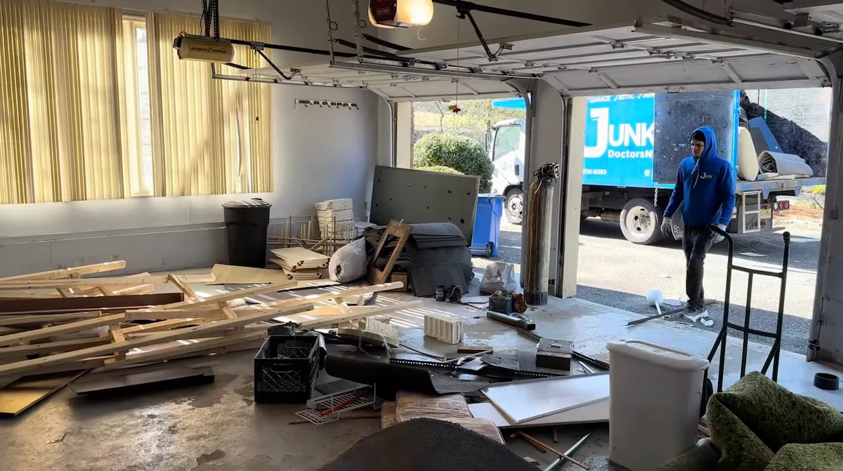 A JunkDoctors NJ team member loading a truck during a full garage cleanout and debris removal service.