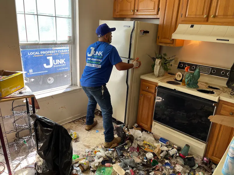 Junk Doctors NJ team member removing an old refrigerator from a kitchen during a residential appliance disposal project in North NJ.