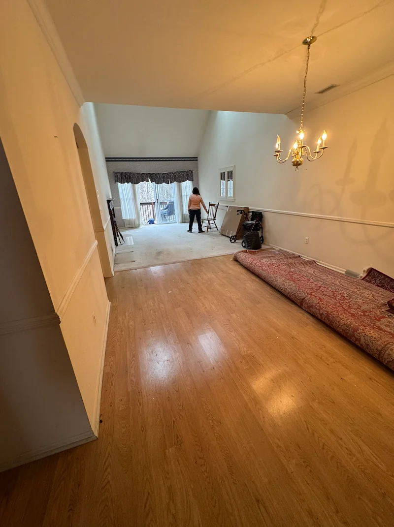 After photo of the same room completely cleared of furniture, showing clean hardwood floors and a vacant space ready for a new tenant.
