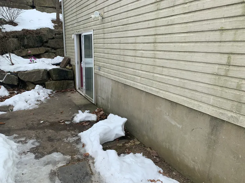 The same snowy patio from the previous image, now completely cleared of all trash bags, chairs, and debris after a JunkDoctors NJ winter yard cleanup.