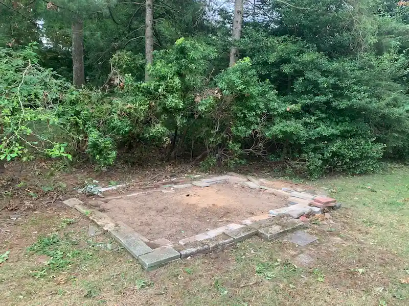 A North Jersey backyard with an old wooden shed fully demolished and hauled away, leaving a clean area.