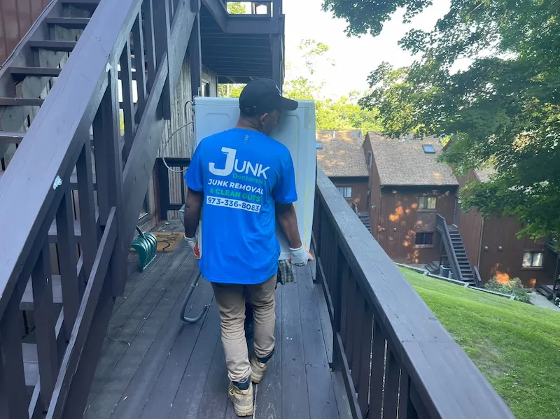 Uniformed crew member removing junk from an apartment building.